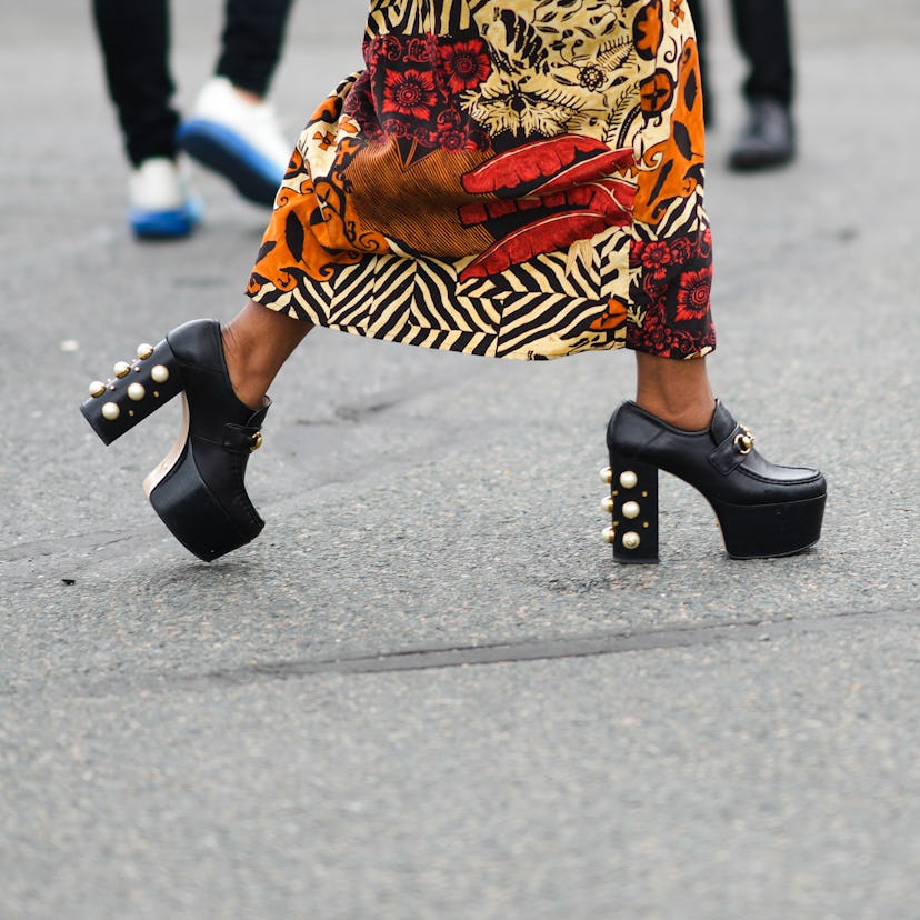 PARIS, FRANCE - OCTOBER 02: A guest wears a yellow with orange and black print pattern oversized puf...