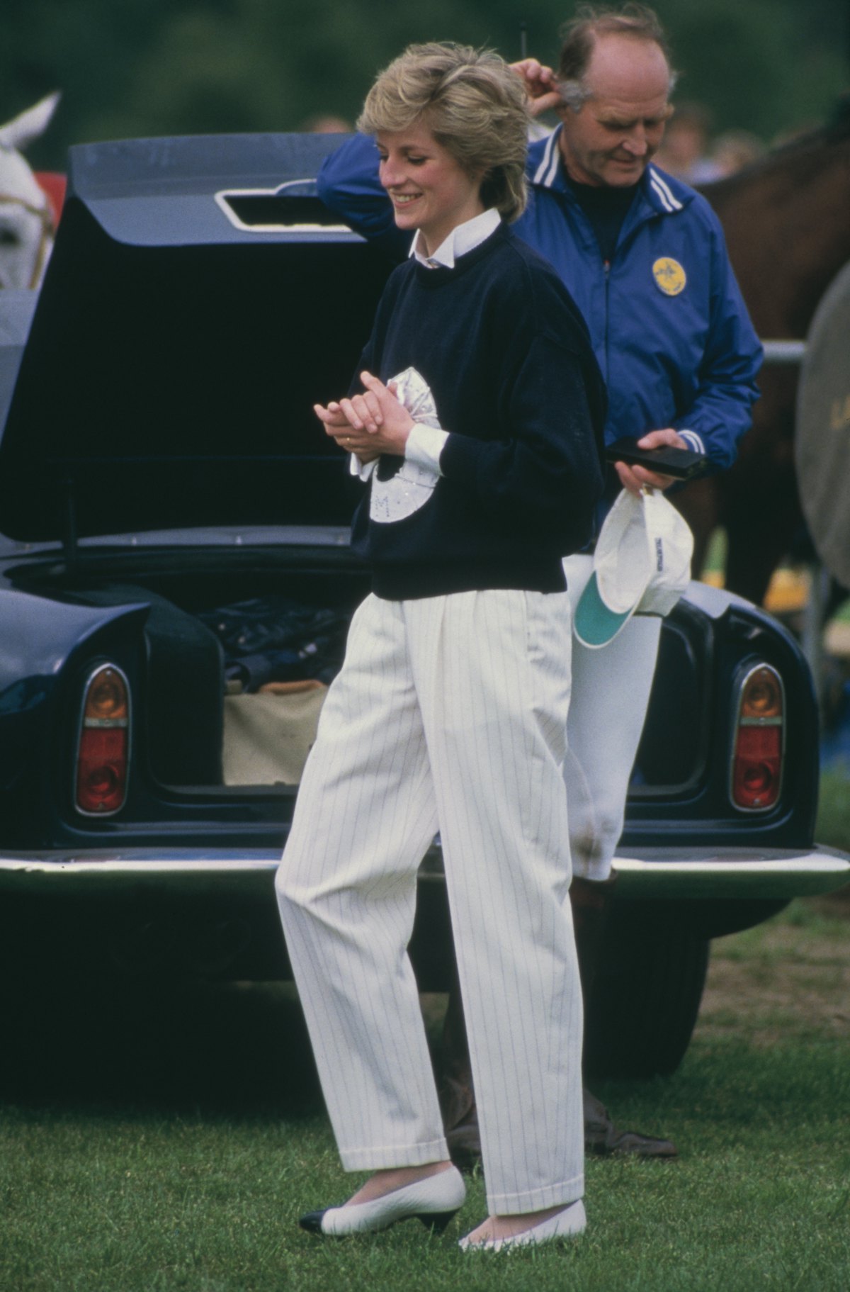 Diana, Princess of Wales wearing a navy blue sweater and straight leg white trousers at a Guards Pol...