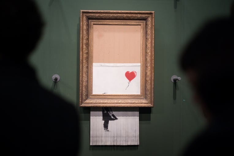 07 March 2019, Baden-Wuerttemberg, Stuttgart: Visitors stand in front of the shredded Banksy picture...