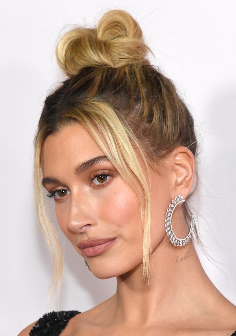 Hailey Bieber wears her hair in a messy bun with face-framing tendrils at the premiere of YouTube Or...