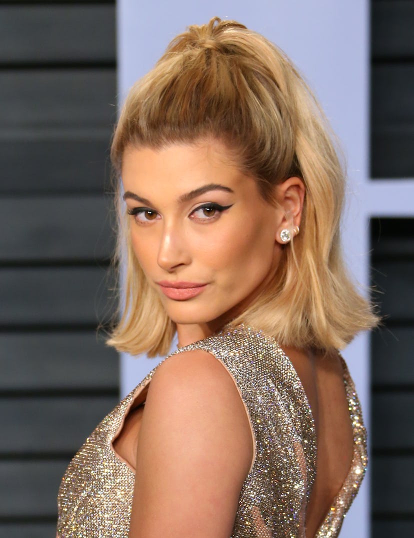 Hailey Baldwin wears her hair half-up at the 2018 Vanity Fair Oscar Party following the 90th Academ…