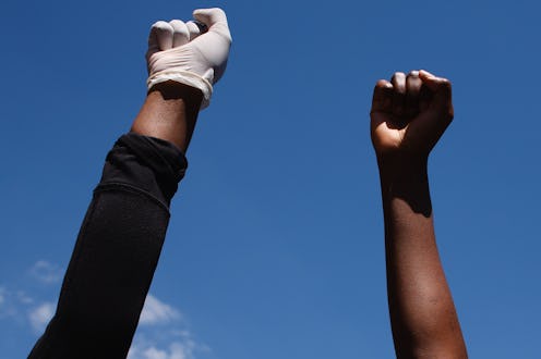 Activists gathered in protest at the killing of George Floyd raise fists outside the US embassy in L...