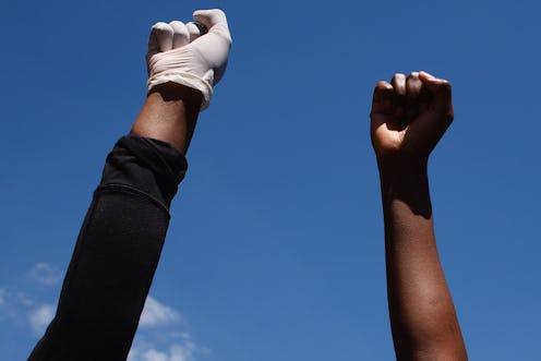 Activists gathered in protest at the killing of George Floyd raise fists outside the US embassy in L...