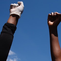 Activists gathered in protest at the killing of George Floyd raise fists outside the US embassy in L...