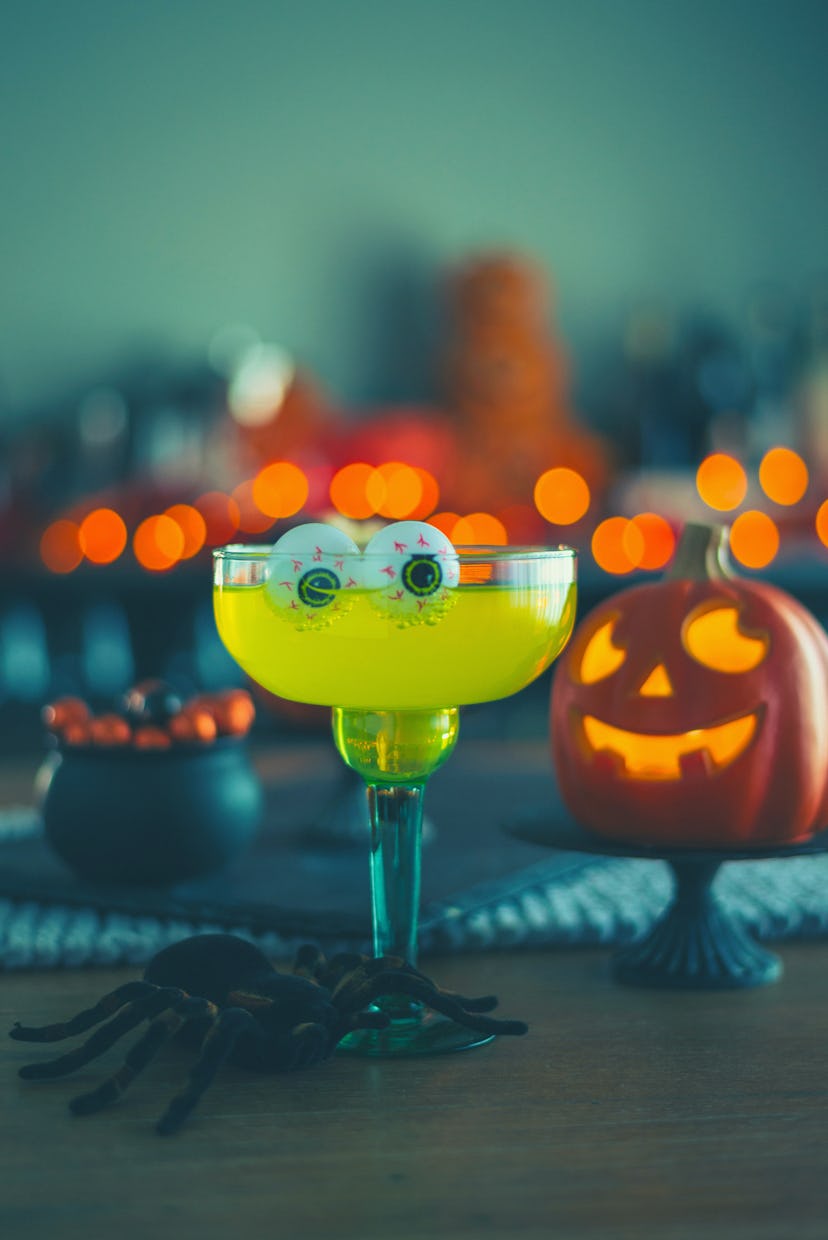 Halloween time. Vibrant colored drinks with cauldron of popcorn