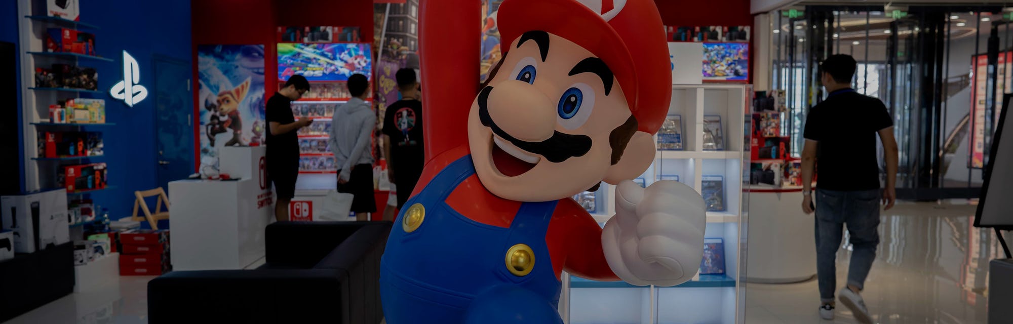 TIANJIN, CHINA - 2021/07/20: A cartoon figurine of Super Mario Bros. stands in front of a Nintendo S...