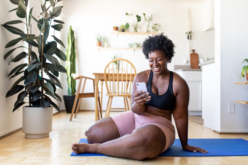 A woman checks her finsta after doing yoga. Gen Z shares finsta bio ideas.