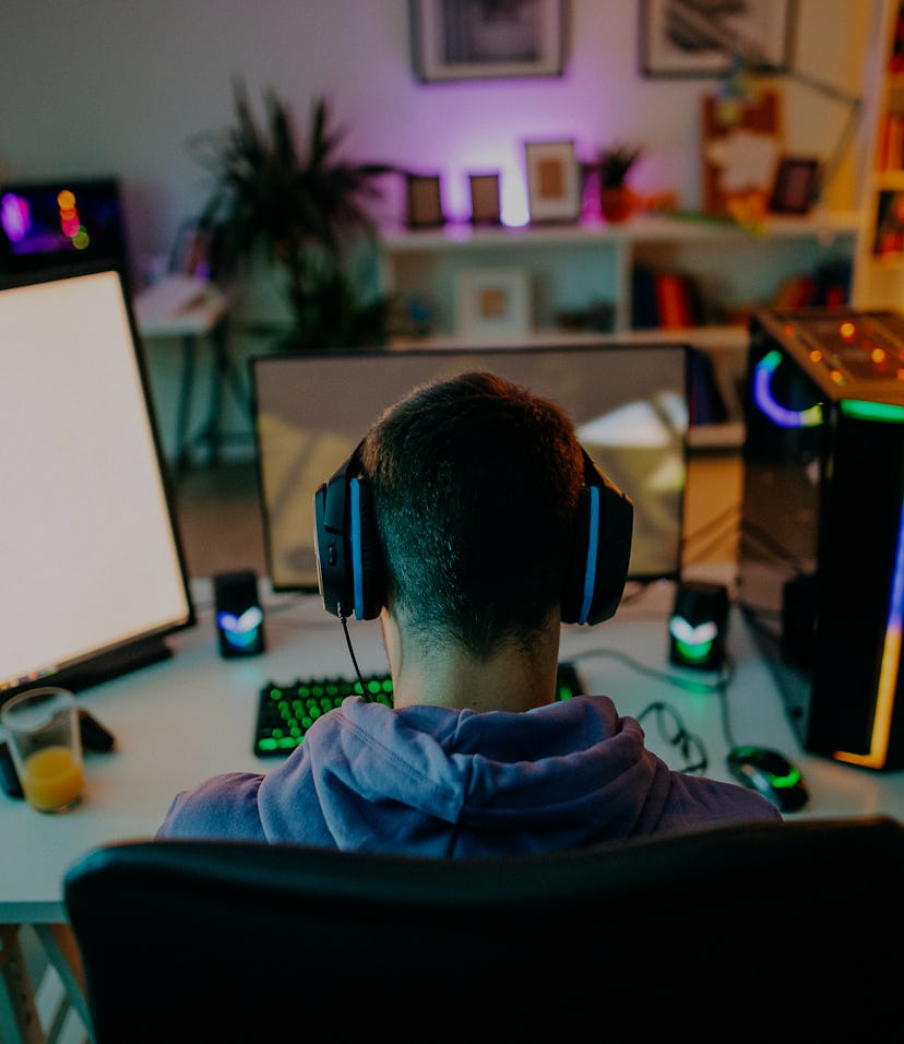 Young man playing online video games at home on PC