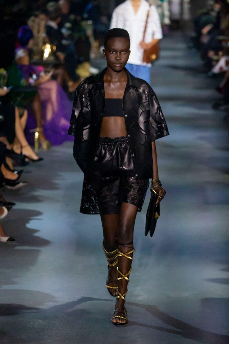 A model walking in a black top and shorts at the Valentino Ready to Wear Spring/Summer 2022 fashion ...