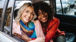 two friends smiling and laughing as they chat about the most romantic day in December 2021 for their...
