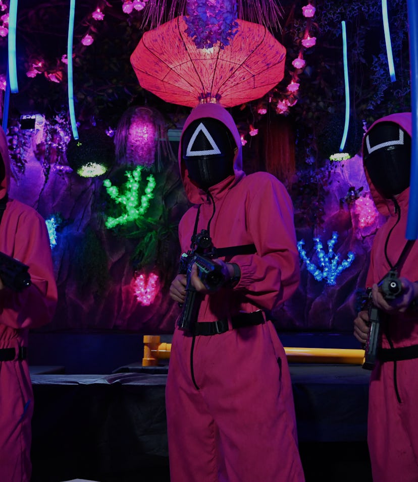 Waiters dressed in outfits from the Netflix series Squid Game pose while playing a game to attract c...