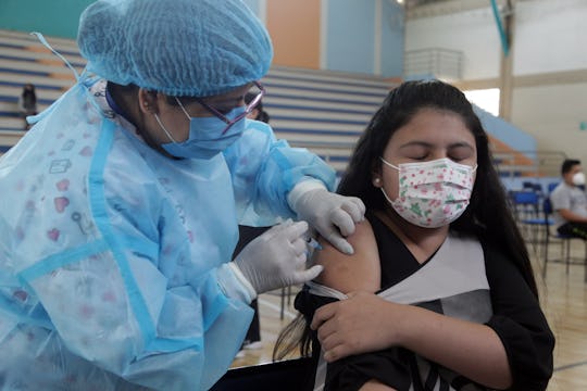 CUENCA, ECUADOR - OCTOBER 18: A healthcare worker administers the first dose of a Pfizer vaccine as ...