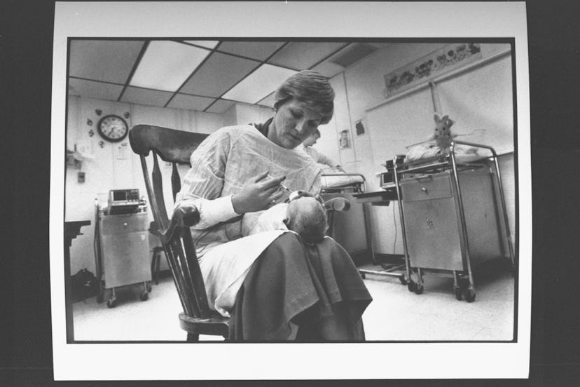 A head nurse feeds a drug-addicted baby in a maternity ward.