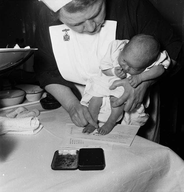A nurse stamps the footprint of a baby in a vintage maternity ward.