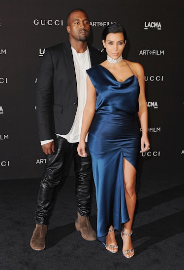Kanye West in a black blazer and leather pants and Kim Kardashian West in a blue gown at the 2014 LA...