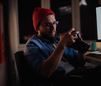 Young man looking at the camera while working late in his home office