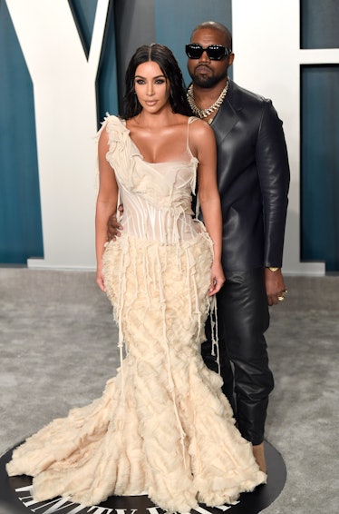 Kim Kardashian in a beige gown and Kanye West in a leather suit at the 2020 Vanity Fair Oscar Party 