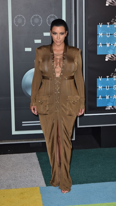 Kim Kardashian at the 2015 MTV Video Music Awards in a dark green dress with laces down the middle 