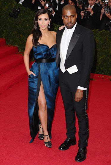 Kim Kardashian in a blue gown with a slit on one leg and Kanye West in a tuxedo at the Met Gala 