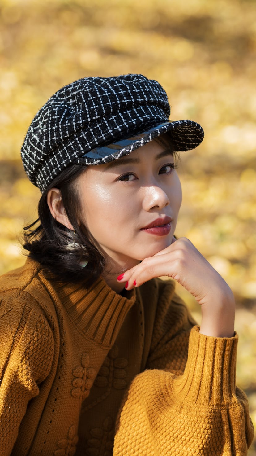 A woman in a hat looks at the camera. Scorpio season 2021 is passion-driven.