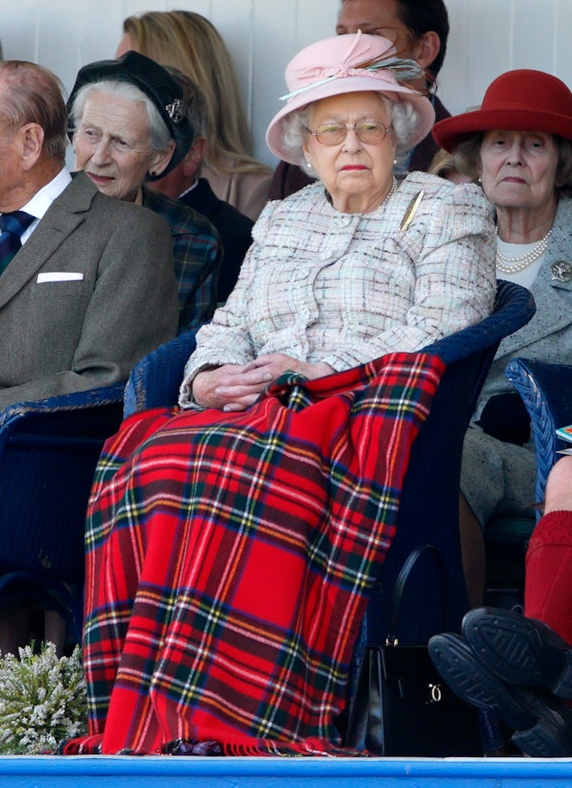 Queen Elizabeth stays warm under a plaid blanket.