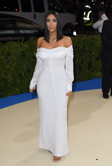 Kim Kardashian at the Met Gala in an off-the-shoulder, floor-length, white gown 