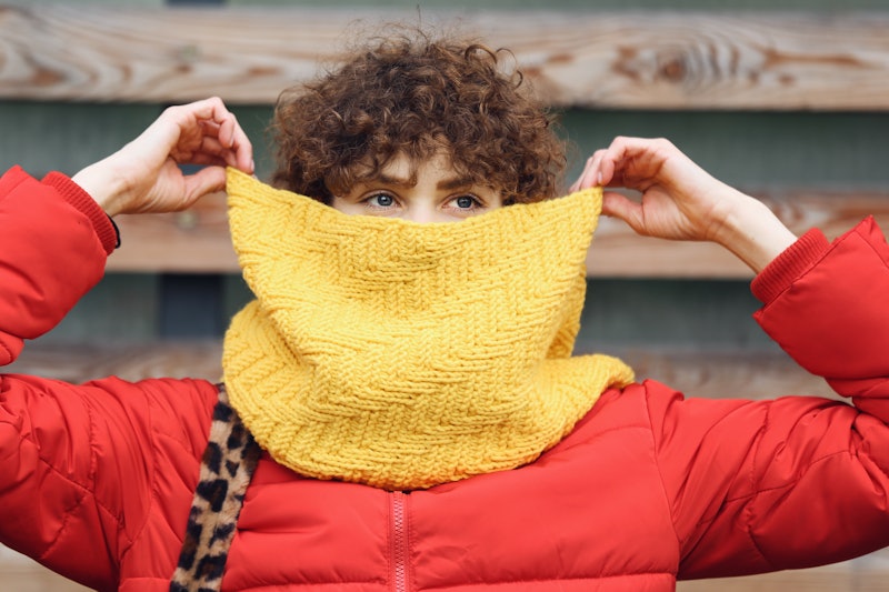 A person holds a yellow scarf over their face. Scorpio season 2021 will have you experiencing intens...