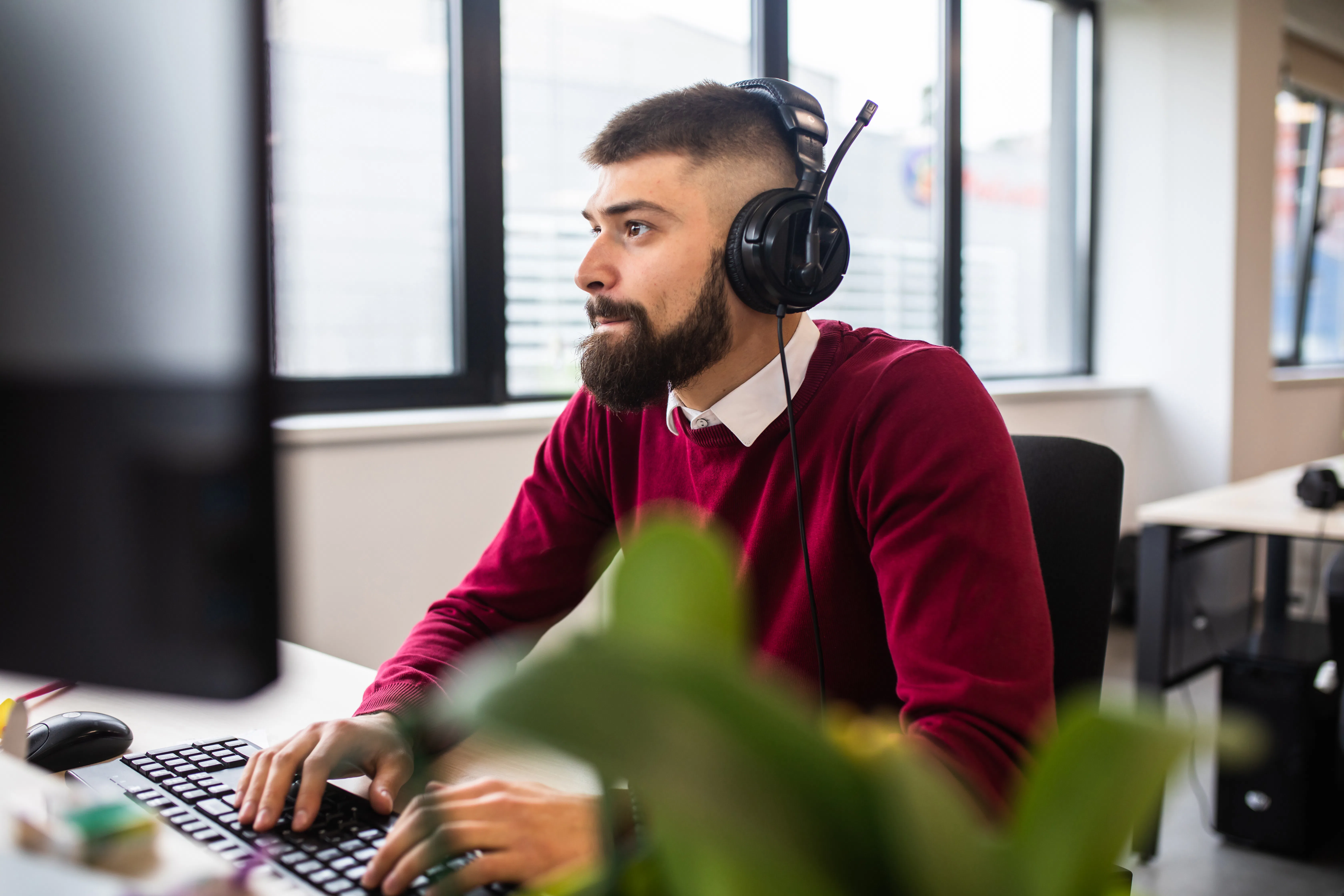 A young man is working on his computer at the office