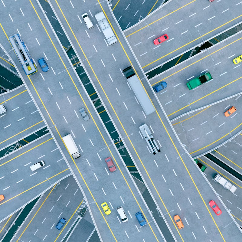 Cars, busses and trucks drive on multiple lane highways. Seen from above. Concept of mobility. 
The ...