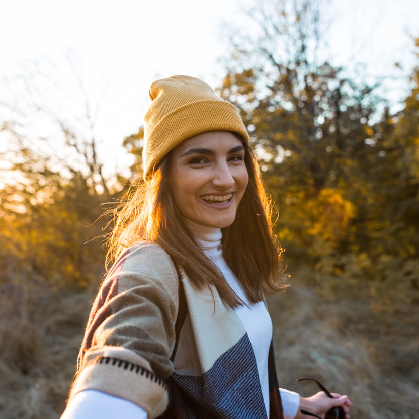 Young woman in autumn forest, thinking about how her zodiac sign will have the best week of November...