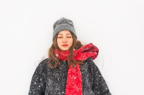 A young woman lying in the snow