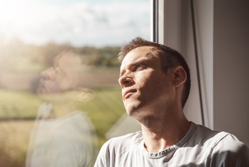 man sitting next to the window on a sunny day