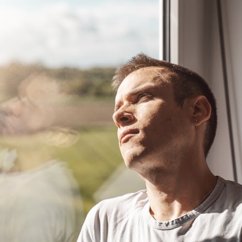 man sitting next to the window on a sunny day