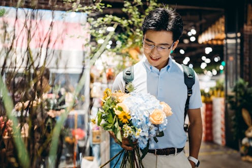 Asian young man buying flowers in flower shop.