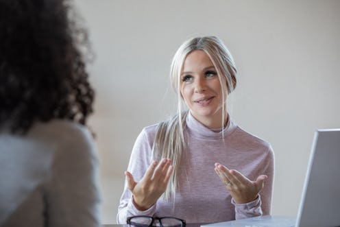 Young woman discussing resume with someone during job interview