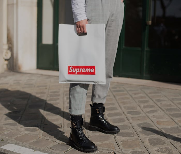 PARIS, FRANCE - SEPTEMBER 26: A guest poses with a Supreme shopping bag after the Dior show at the M...
