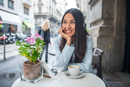 Beautiful smiling young Asian woman having a relaxing time at Cafe