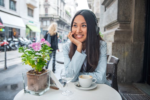 Beautiful smiling young Asian woman having a relaxing time at Cafe
