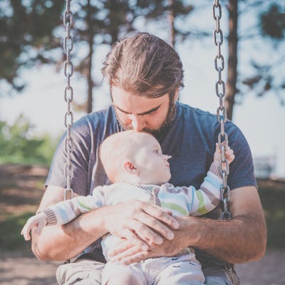 DSLR picture of a 9 months old Baby Boy Sitting in Playground Swing Outdoors on a nice day of summer...