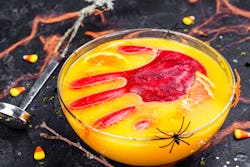 A nonalcoholic halloween punch with a large red ice cube in the shape of a hand.
