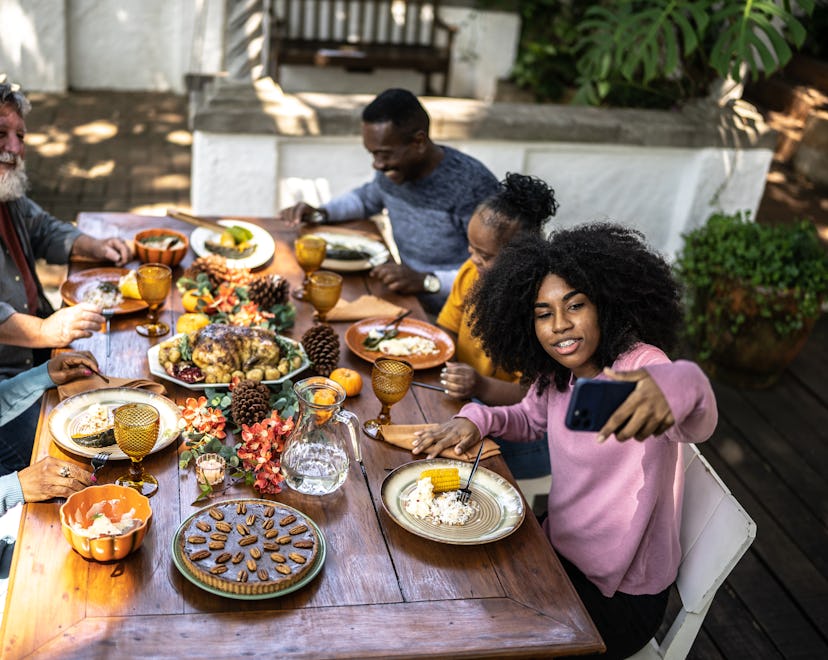Family eating thanksgiving outdoors getting ready to take a selfie; instagram captions for thanksgiv...