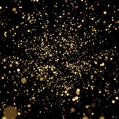 Splash of glittering golden confetti on black isolated background. Christmas and New Year concept in...