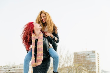 two women piggyback riding as they chat about December 19, 2021 being the most romantic day in of th...
