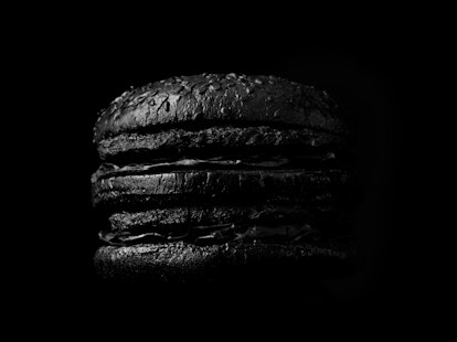 Black burger shot on black backdrop