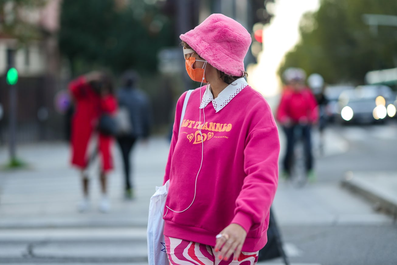 PARIS, FRANCE - SEPTEMBER 29: A guest wears a pink fluffy bob hat, white sunglasses, a white shirt, ...