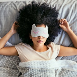 Shot of a young woman sleeping with a mask on in bed