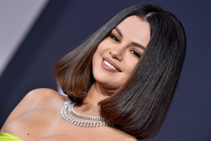 Selena Gomez poses on the red carpet with her hair in a straightened above-the-shoulder bob, parted ...