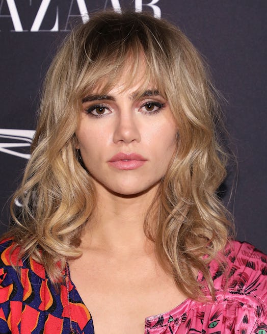Suki Waterhouse wears her blonde hair in a '70s-inspired shag with front fringe and waves.