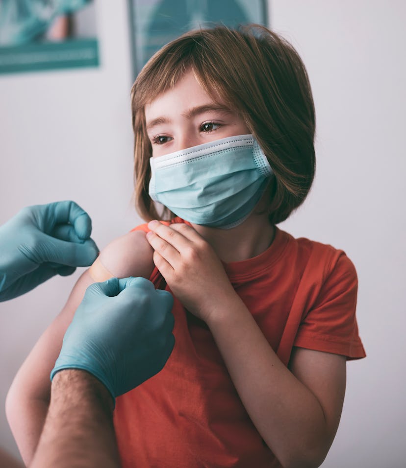 Doctor putting adhesive bandage to a child after Covid-19 vaccine injection.
