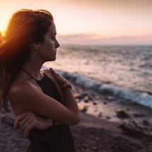 A woman stares moodily at the beach. An astrologer explains cancer zodiac signs' biggest weaknesses.